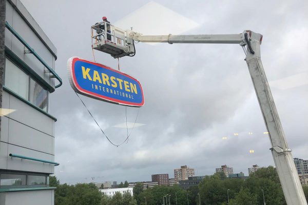 Reclamebord wordt opgehangen op het kantoorpand van Karsten International